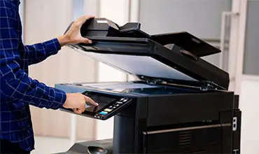 Businessmen press button on the panel for using photocopier.
