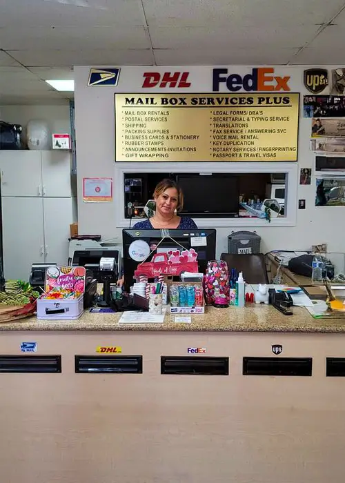 Woman standing behind the counter at mail boxes n more.