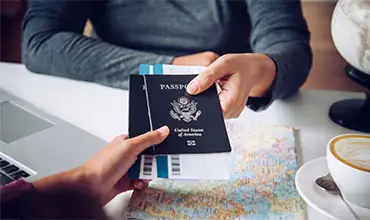 Hand for tourist holding passport to authorities.