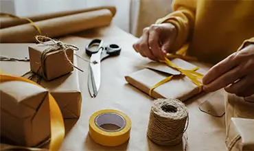 Woman packaging box. Kraft wrapping paper and natural twine.